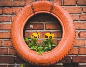 A repurposed tire planter with flowers in it
