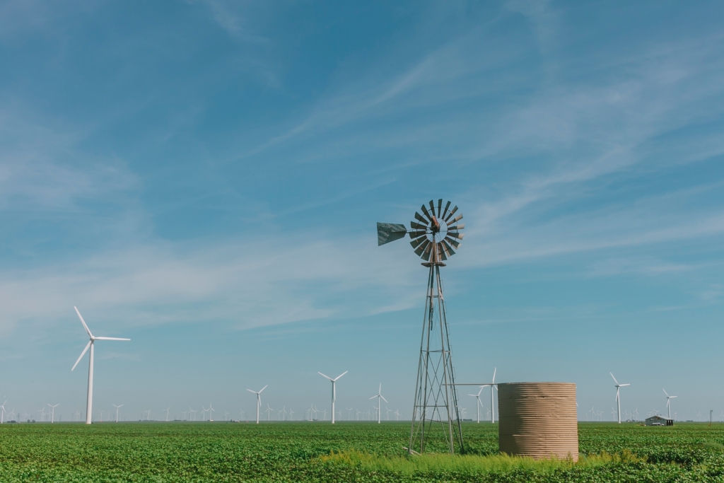 A open windmill over a crop farm