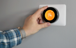 A hand changing the temperature of the thermostat