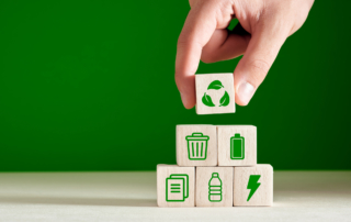Recycling and environmental protection concept. Environment sustainable development. Hand puts recycling product material symbols on green background.