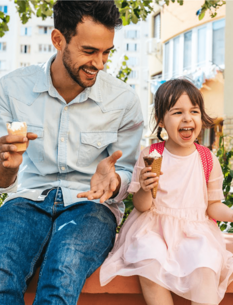 Dad eating popsicles with his child in the summer