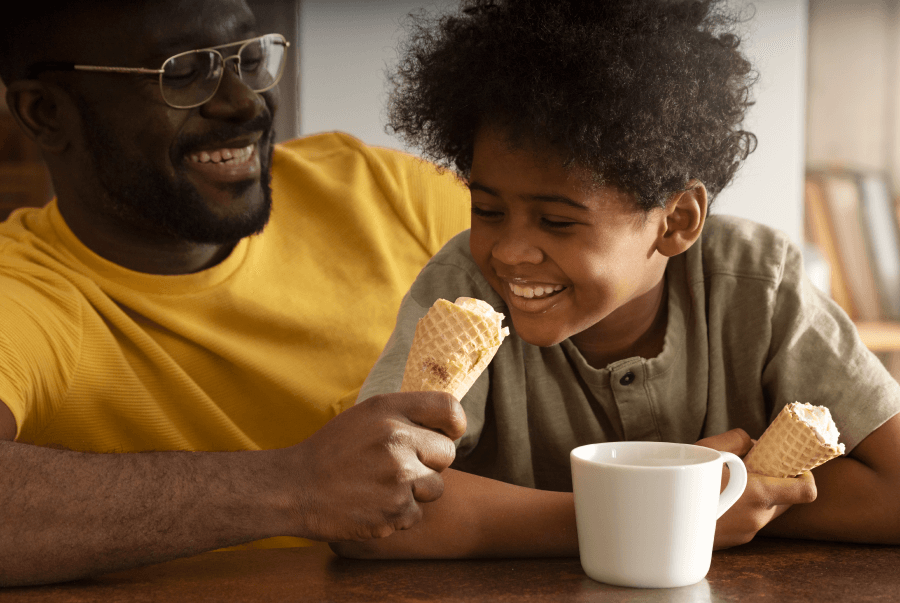 Dad eating popsicles with his child in the summer